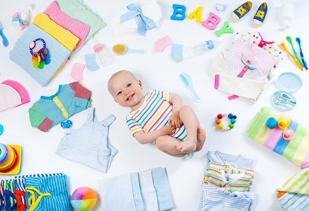 baby surrounded by cloth and toys